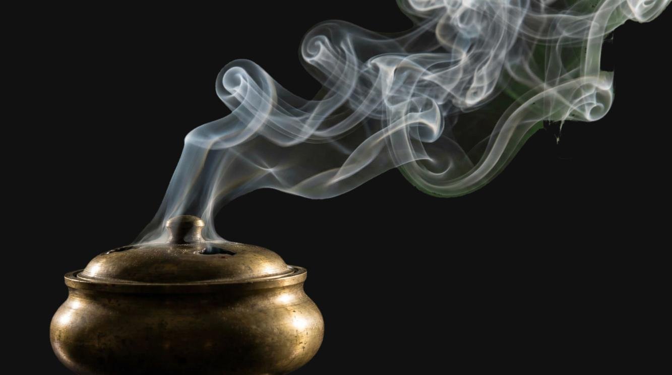 Incense smoke rising from a brass burner